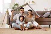 Happy family under fake roof in living room