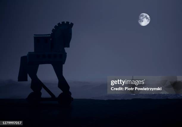 trojan horse standing on beach with moon over ocean. - trojan horse stock pictures, royalty-free photos & images