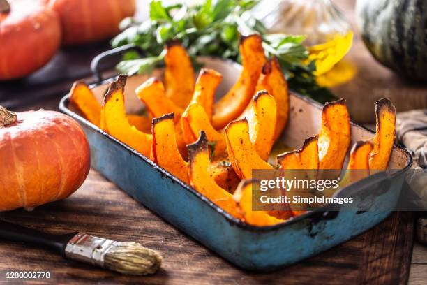 roasted pumpkin hokkaido in olive oil salt pepper and celery herbs. - squash seeds stock-fotos und bilder