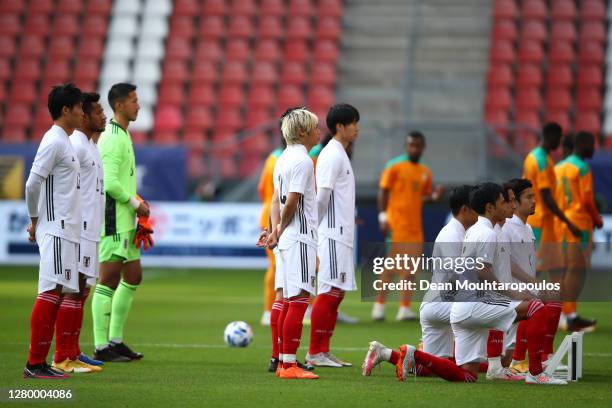 Japan players socially distance while posing for a team photo ahead of the international friendly match between Japan and Ivory Coast at Stadion...