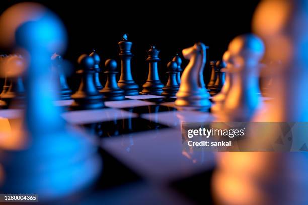 close up of chessmen on chessboard with the focus on a queen - chess championship stock pictures, royalty-free photos & images