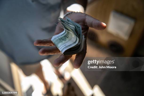 Hector Medrano delivers cash to a landlord while narrowly avoiding eviction from an RV park on October 07, 2020 in Phoenix, Arizona. Medrano was able...