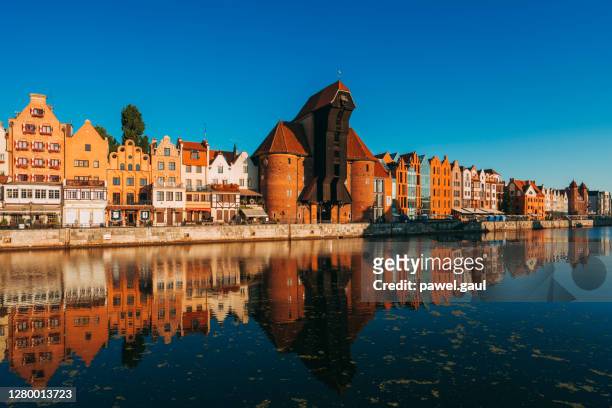 gdansk waterfront with crane gate and motlawa river at sunrise in poland - gdansk stock pictures, royalty-free photos & images