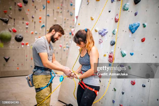 partners readying rope en harness devices voor sport climb - zekeren stockfoto's en -beelden