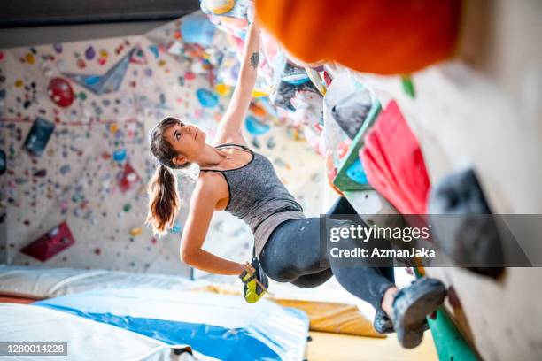 sportswoman reaching into chalk bag on bouldering wall - bouldering stock pictures, royalty-free photos & images