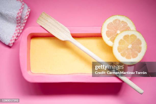 lemon cake pan with raw cake dough on marble table and a pink silicone pan. - butter tart stock pictures, royalty-free photos & images