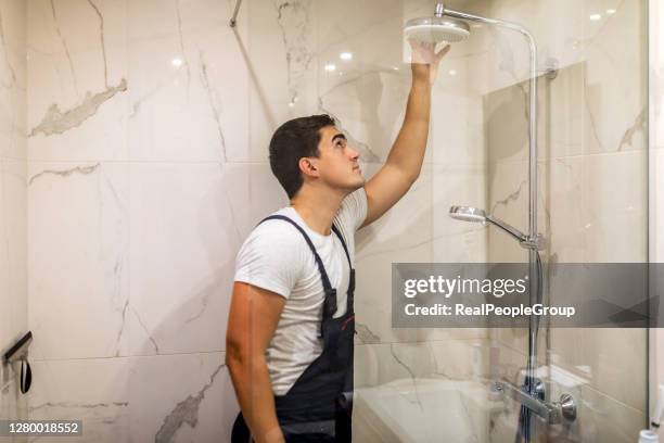 het vervangen van het sanitair in de badkamer gemonteerde hand douchehouder met hoogte verstelbaar een douchekop. - leg stockfoto's en -beelden