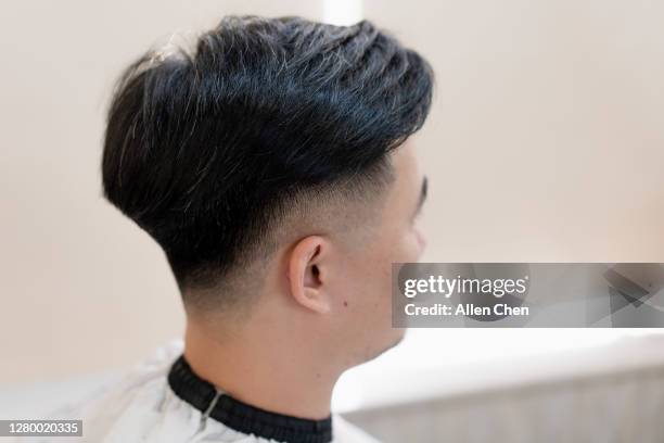 the handsome young chinese man is having his hair cut - haar knippen stockfoto's en -beelden
