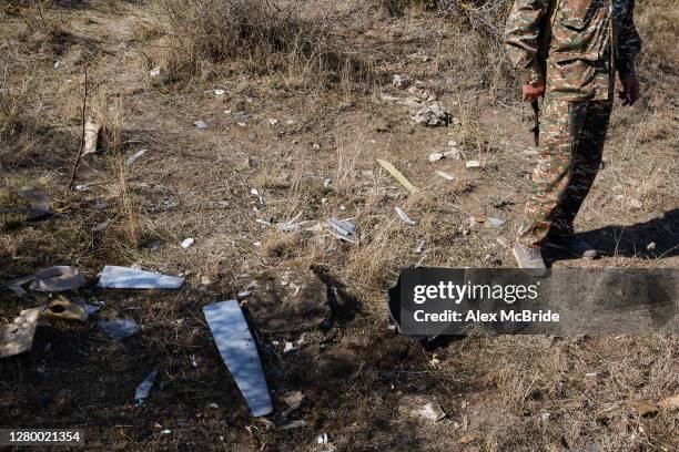 Soldier stands beside the remains of a downed Azeri drone on the outskirts of Askeran on October 13, 2020 in Askeran, Nagorno-Karabakh. Although...