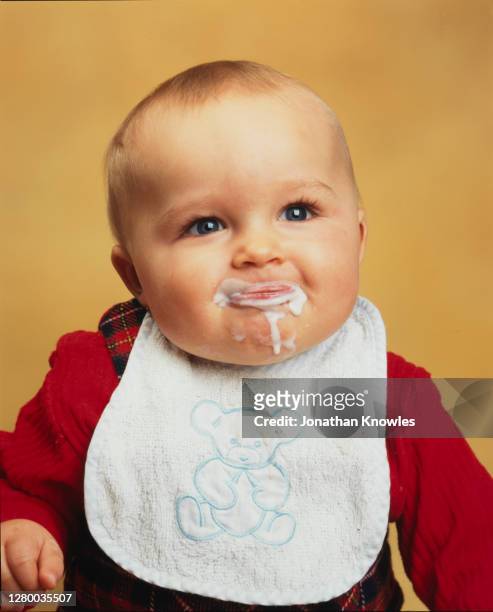 cute baby dribbling food - よだれ掛け ストックフォトと画像