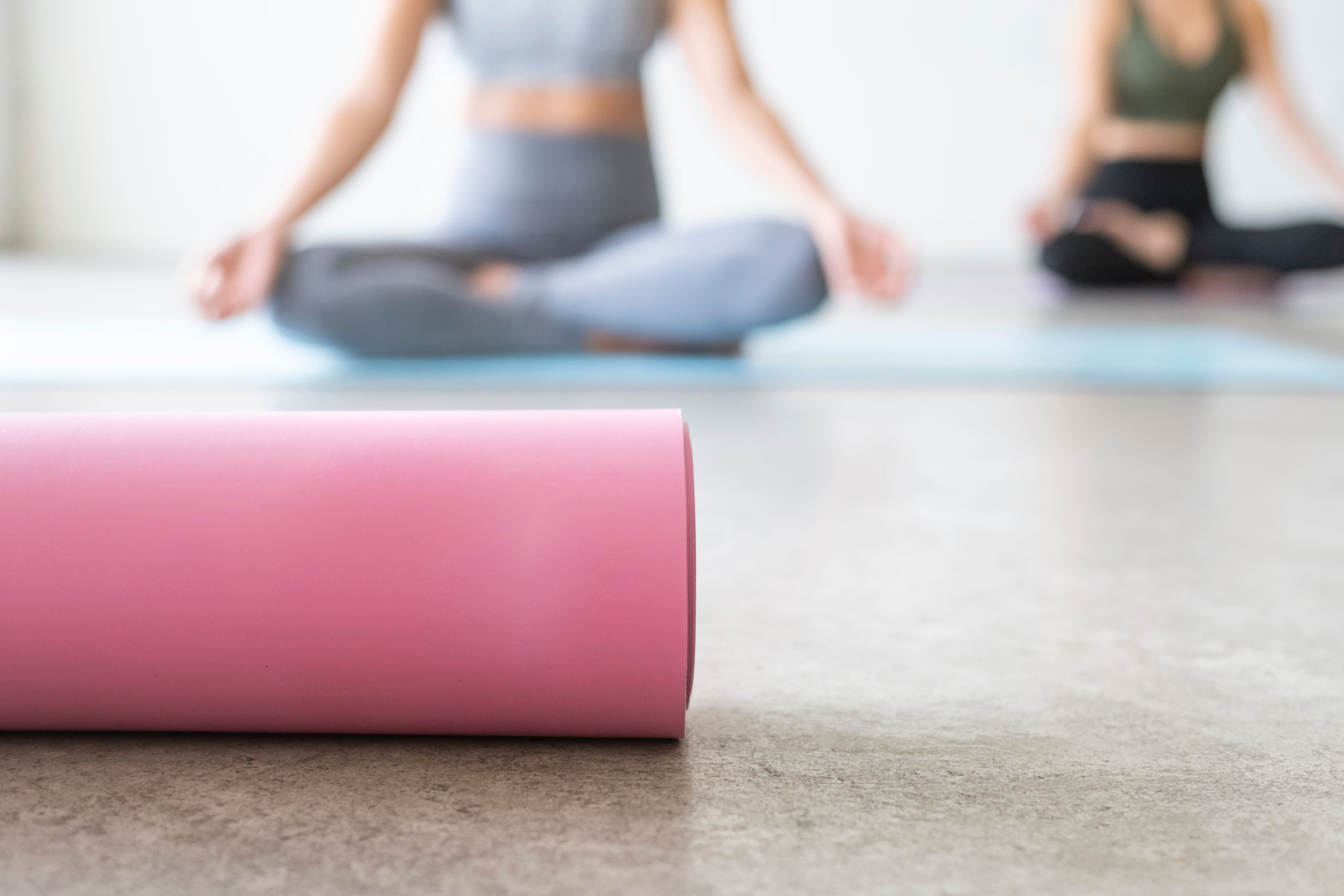 Athletic women meditating in yoga class Athletic women meditating in yoga class