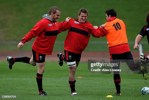 Gethin Jenkins, Jonathan Davies and Stephen Jones warm up during a Wales IRB Rugby World Cup 2011 media session at Newtown Park on October 5, 2011 in...