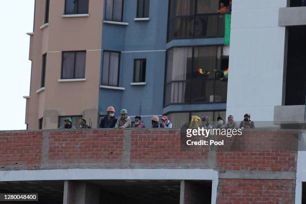 Men watch the game from a building next to Hernando Siles Stadium during a match between Bolivia and Argentina as part of South American Qualifiers...