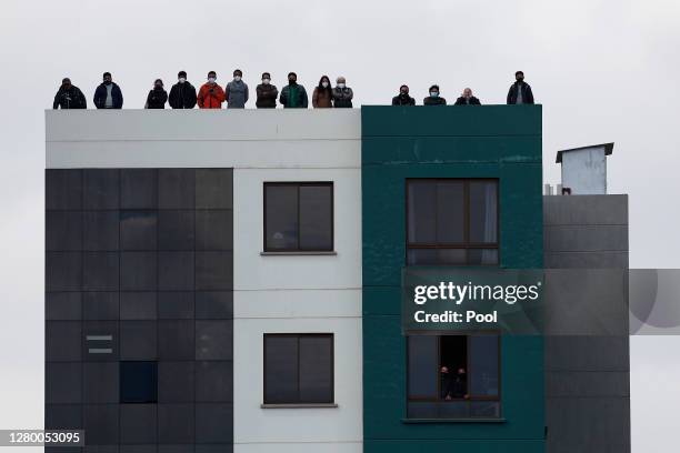 Fans watch the match between Bolivia and Argentina from a building next to Estadio Hernando Siles on October 13, 2020 in Miraflores, La Paz, Bolivia....