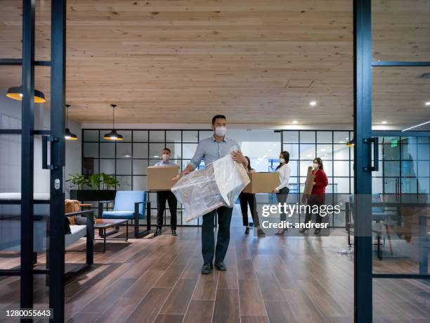 zakenmensen die zich in een nieuw bureau bewegen dat gezichtsmaskers draagt - opening a box stockfoto's en -beelden