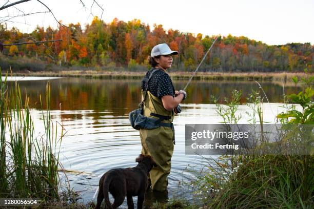 a teenaged fly-fisherman with his labrador puppy - wading boots stock pictures, royalty-free photos & images