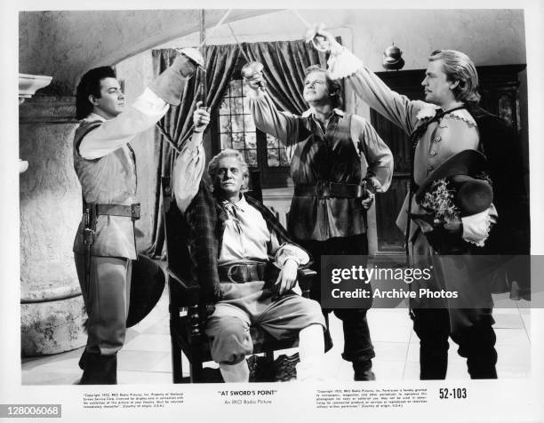 Standing from left, Cornel Wilde, Alan Hale Jr, and Dan O'Herlihy, along with an unidentified, seated actor raise their swords in a scene from the...