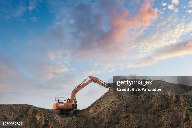 een graafmachine die vuil in een zandput opgraaft - shovel stockfoto's en -beelden