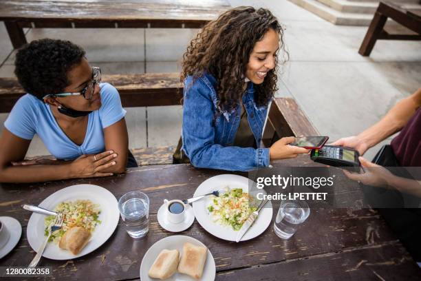 betalen per telefoon - black couple dining stockfoto's en -beelden