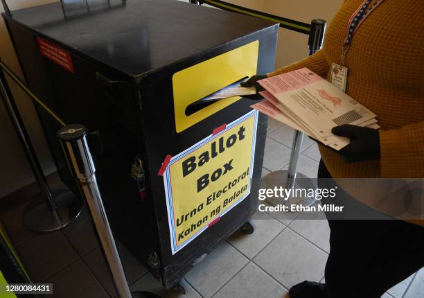 Clark County Election Department worker Breanna Silas puts mail-in ballots collected from vehicles in a ballot box at the Clark County Election...