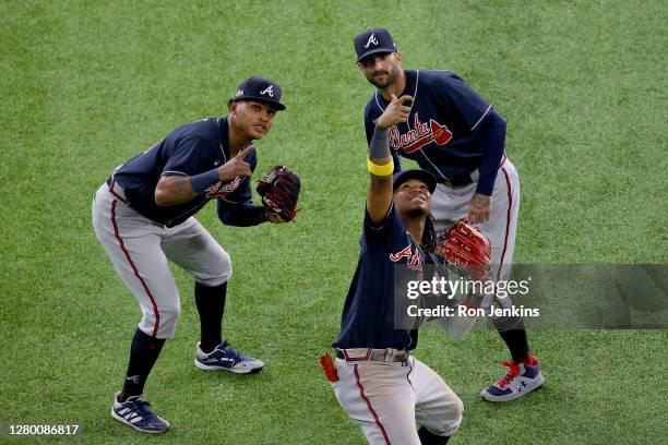 Ronald Acuna Jr. #13, Cristian Pache and Nick Markakis of the Atlanta Braves celebrate with a pretend selfie after the teams 8-7 victory against the...