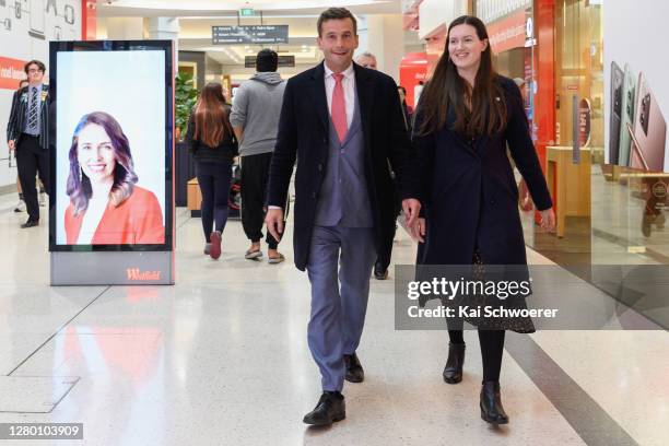 Leader David Seymour and ACT deputy leader Brooke van Velden walk past a LED screen showing New Zealand Prime Minister Jacinda Ardern on October 14,...