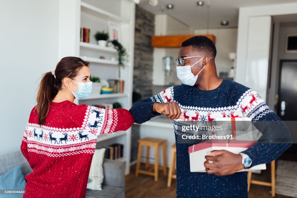 Young Caucasian woman welcoming her African American friend to her home