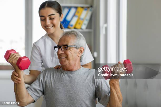 nurse and male patient exercising - hand weight stock pictures, royalty-free photos & images