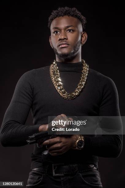 portrait of an armed young black male in studio shoot - man studio shot stock pictures, royalty-free photos & images
