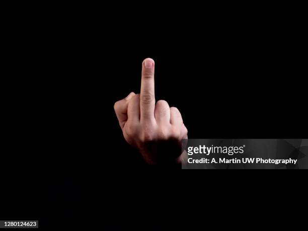 middle finger, offensive gesture. fuck you concept. black background - mid section fotografías e imágenes de stock