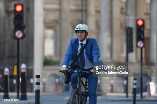 uomo d'affari londinese socialmente responsabile in bicicletta per lavorare - stoplight foto e immagini stock