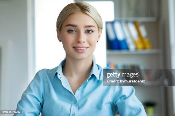 smiling young woman having video call at home - virtual coach stock pictures, royalty-free photos & images