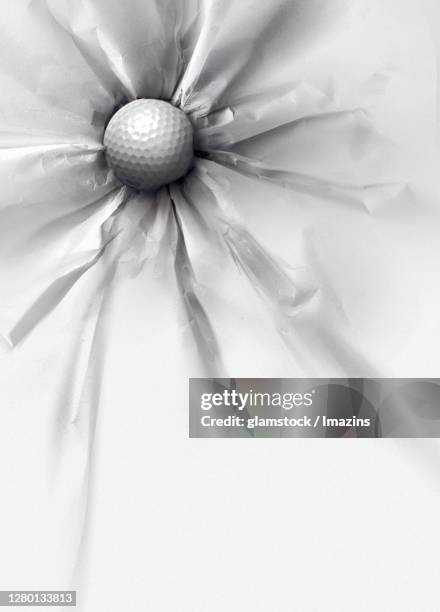 a golf ball stuck on wall - crumpled paper ball stock-fotos und bilder