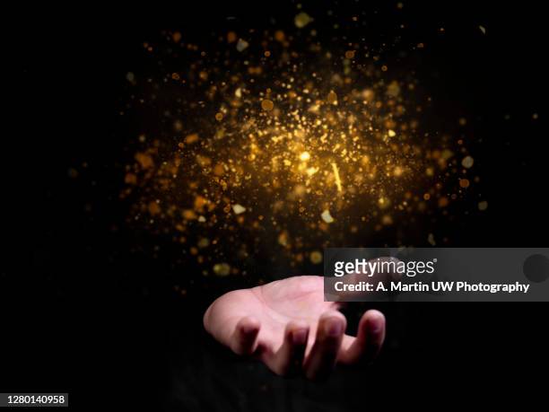 praying hands with faith in religion and belief in god on blessing background. power of hope or love and devotion. magic powder floating on the magician hand. - magician stock pictures, royalty-free photos & images