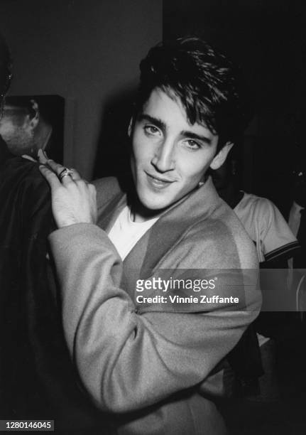 American singer Jonathan Knight, of boyband New Kids on the Block, with his left arm resting on the shoulder of an unidentified person, circa 1990.