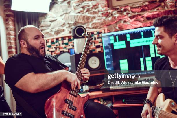bassist aufgeregt bei auftritt mit gitarrist im studio - bass gitarre stock-fotos und bilder