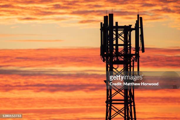 Mobile phone transmitter silhouetted against an orange sunset on October 11, 2020 in Cardiff, Wales.