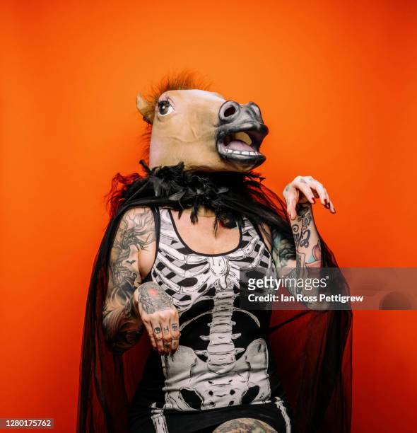 halloween - female model wearing horse head mask with skeleton shirt - horse studio stock-fotos und bilder