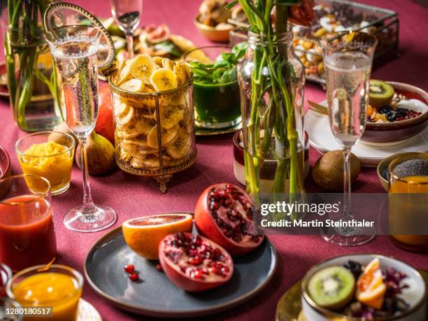 frühstückstisch mit früchten, granatapfel und prosecco - granatapfel stockfoto's en -beelden