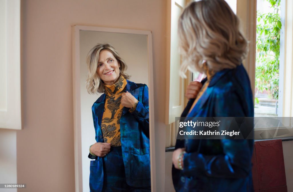 Beautiful mature woman checking herself in the mirror