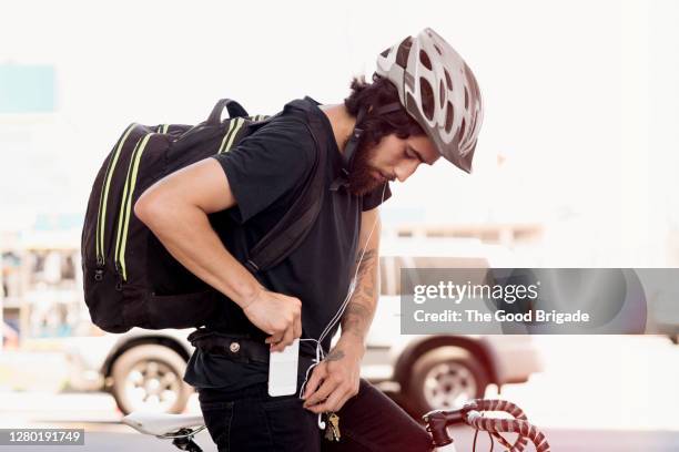 man on bike with smart phone - pocket stock pictures, royalty-free photos & images