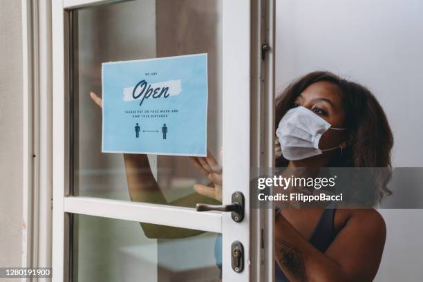 slow motion video young woman with a reopening sign in her gym - store opening covid stock pictures, royalty-free photos & images