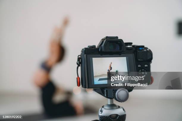 yoga teacher is recording a pregnancy yoga lesson to upload it online - studio camera stock pictures, royalty-free photos & images