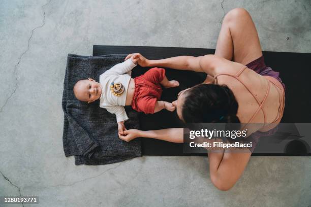 mother having fun with her little kid during a yoga class - mom exercising stock pictures, royalty-free photos & images