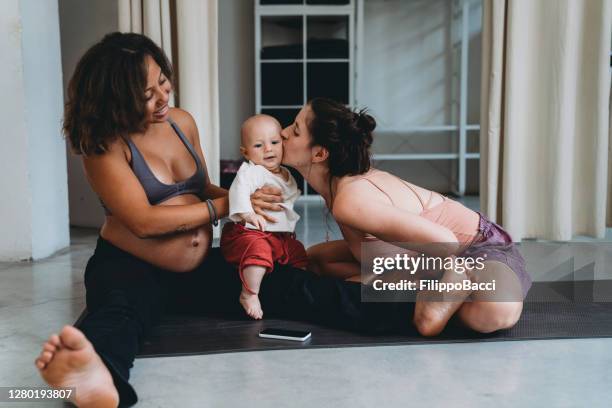 two young women playing with their son in a yoga studio - 3 gym stock pictures, royalty-free photos & images