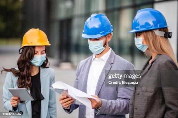 business people working and wearing helmet and protective face mask during pandemic of coronavirus - new business covid stock pictures, royalty-free photos & images