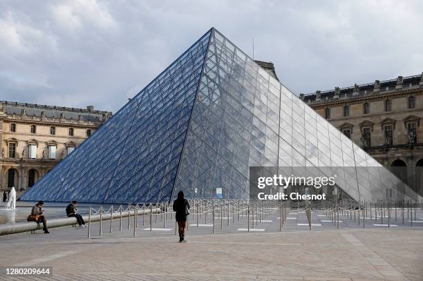 The almost empty courtyard of the Louvre museum and the pyramid of Louvre are seen without tourists on October 14, 2020 in Paris, France. Deserted...