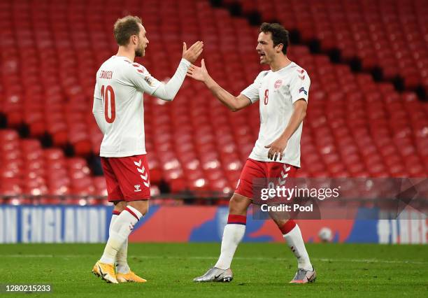 Christian Eriksen of Denmark celebrates after he scores his team's first goal from the penalty spot past Jordan Pickford of England during the UEFA...