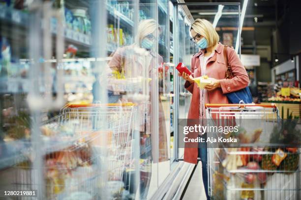 donna che sceglie il formaggio al supermercato. - cibi surgelati foto e immagini stock