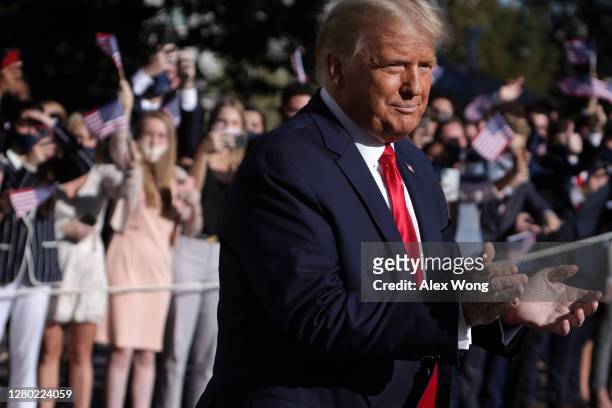 President Donald Trump comes out from the residence as supporters react prior to a Marine One departure from the White House October 14, 2020 in...